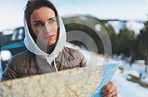 Girl hold in hands looking on map, relax tourist travels by auto car, people planning trip in snow mountain, hipster enjoy winter