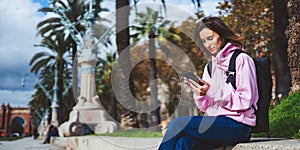 Girl hold in hands mobile phone, person type message on smartphone, relax tourist travels planning trip in sun city, hipster enjoy