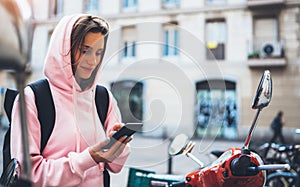 Girl hold in hands mobile phone, person type message on smartphone, tourist traveler planning trip on moto scooter, hipster enjoy