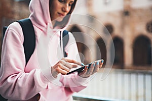 Girl hold in hands mobile phone in sun city, person type message on smartphone, relax tourist travels planning trip, hipster enjoy