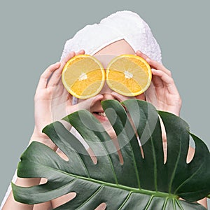 Girl hold orange slice. Citrus fruit hidding face