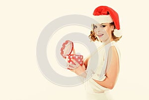 Girl hold polka dot gift box opening christmas present. Girl celebrate christmas. Girl wear santa claus hat. Woman