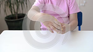 Girl hold and stretching yellow slime with golden braids on a white table. child playing with a slime toy. Making slime.