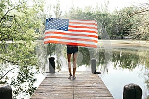 Girl holding an american flag in nature