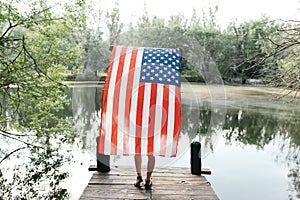 Girl holding an american flag in nature