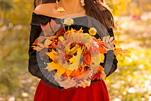 The girl is holding an autumn bouquet