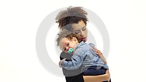 Girl is holding the baby, he has a nipple, he was crying. White background. Slow motion