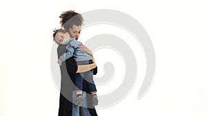 Girl is holding the baby, he has a nipple, he was crying. White background. Slow motion