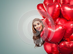 Girl holding balloons hearts. Surprised woman on white background. Surprise, valentines people and Valentine`s day concept