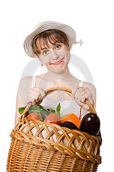Girl holding a basket of fresh vegetables.