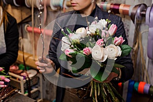 Girl holding a beautiful bouquet of white peony roses and pink tulips