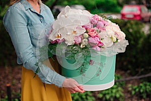 Girl holding beautiful mix white and pink flower bouquet in round box with lid