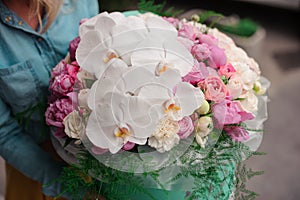 Girl holding beautiful mix white and pink flower bouquet in round box with lid