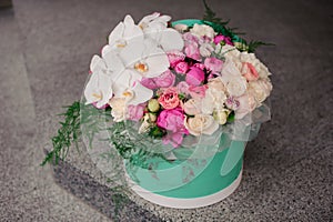 Girl holding beautiful mix white and pink flower bouquet in round box with lid