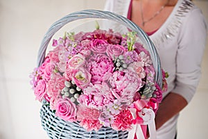 Girl holding beautiful pink bouquet of mixed flowers in basket