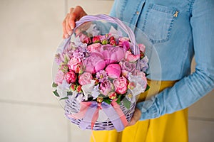 Girl holding beautiful pink bouquet of mixed flowers in basket