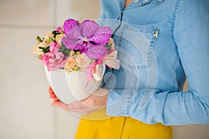 Girl holding beautiful pink bouquet of mixed flowers in vase