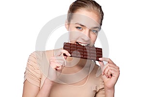 Girl holding big chocolate bar in her tooths