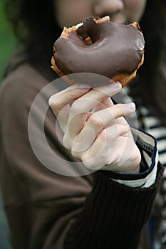 Girl holding bitten doughnut