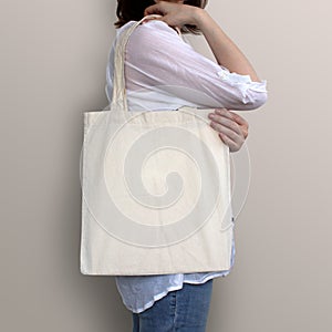 Girl is holding blank cotton eco bag, design mockup.