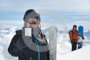 Girl holding blank ski ticket smiling