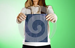 Girl holding a blue gift bag. Close up. background