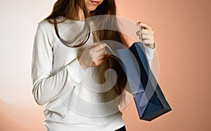 Girl holding a blue gift bag. Close up. Isolated background