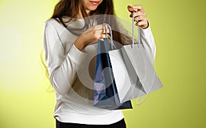 Girl holding a blue and grey gift bags. Close up. backg