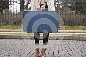 Girl holding blue suitcase