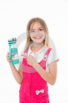Girl holding a bottle of water. Kid with big smile wearing pink jumpsuit. Lovely child isolated on white background