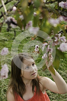 A girl holding a bough of blooming tree