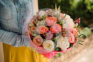 Girl holding Bouquet of the different mixed orange and white flowers