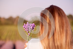 Girl holding a bouquet of fresh lavender in lavender field