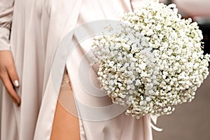 Girl holding a bouquet of white gypsophila, bridal wedding bouquet