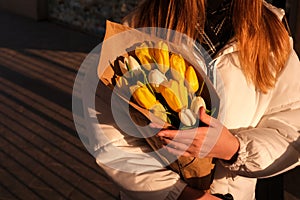 girl holding a bouquet of yellow and white tulips. International Women`s Day. festive bouquet