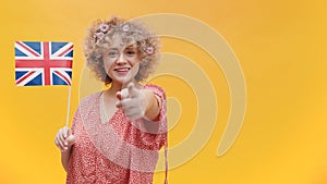 Girl Holding British Flag In Her Hand Pointing With Her Finger At The Camera