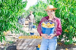 Girl holding bucket of peaches