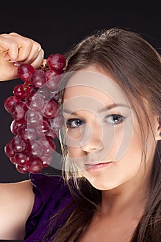 Girl holding bunch of red grapes