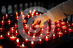 A girl is holding candle and praying near altar in church.