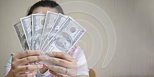 Girl holding cash money in dollar banknotes