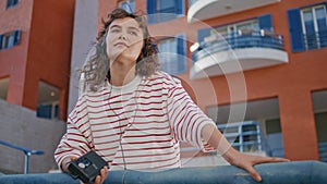 Girl holding cassette player listening music at urban area alone close up.