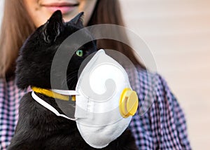 Girl Holding Cat in Hands. Cat wearing medical mask because of Coronavirus or air pollution or virus epidemic in the city. Place