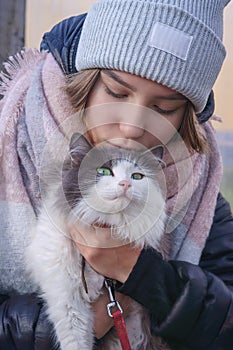 Girl holding a cat in her arms