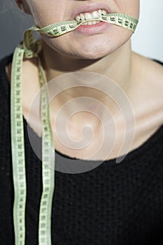 Girl holding a centimeter in her mouth