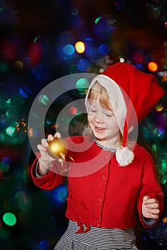 Girl holding Christmas ball and smiles