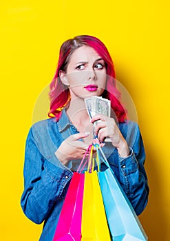 Girl holding a colored shopping bags and money