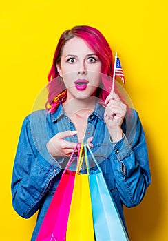 Girl holding a colored shopping bags and USA flag