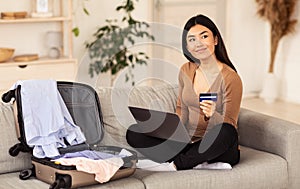 Girl Holding Credit Card Sitting With Laptop On Sofa Indoors