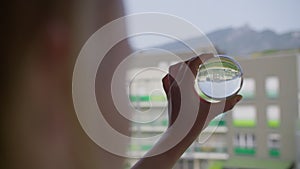 Girl holding crystal ball with upside-down city view