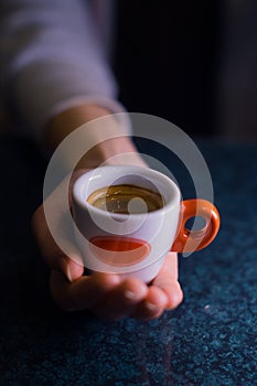 The girl is holding a cup of American coffee.